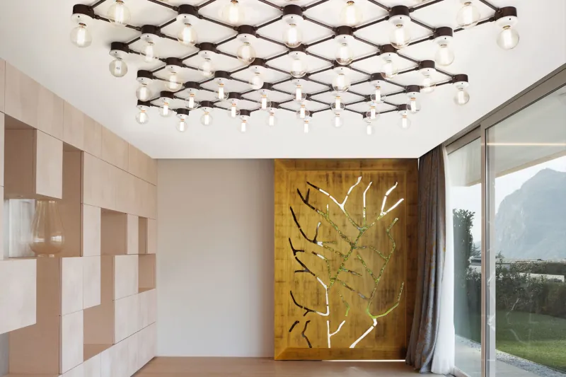Ceiling of exposed bulbs in a hall with a golden screen